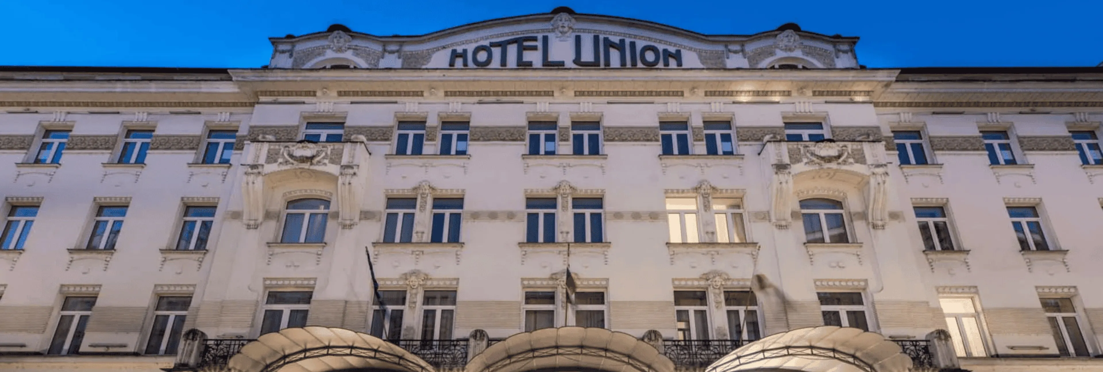 Grand Hotel Union entrance with elegant Art Nouveau facade illuminated at night